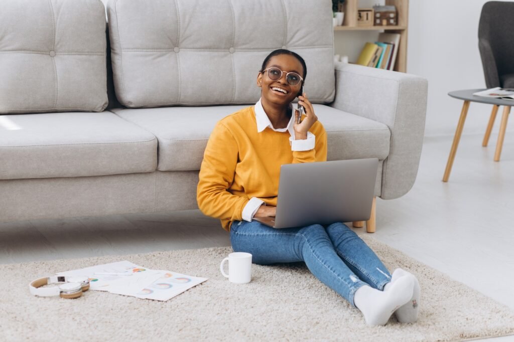 Beautiful young black university student sitting on the floor drinking coffee