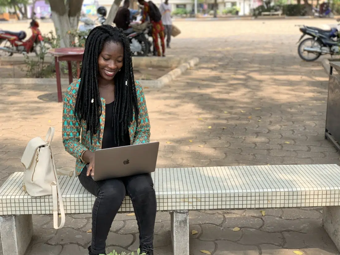 Nigerian student working on her essay on a laptop on campus