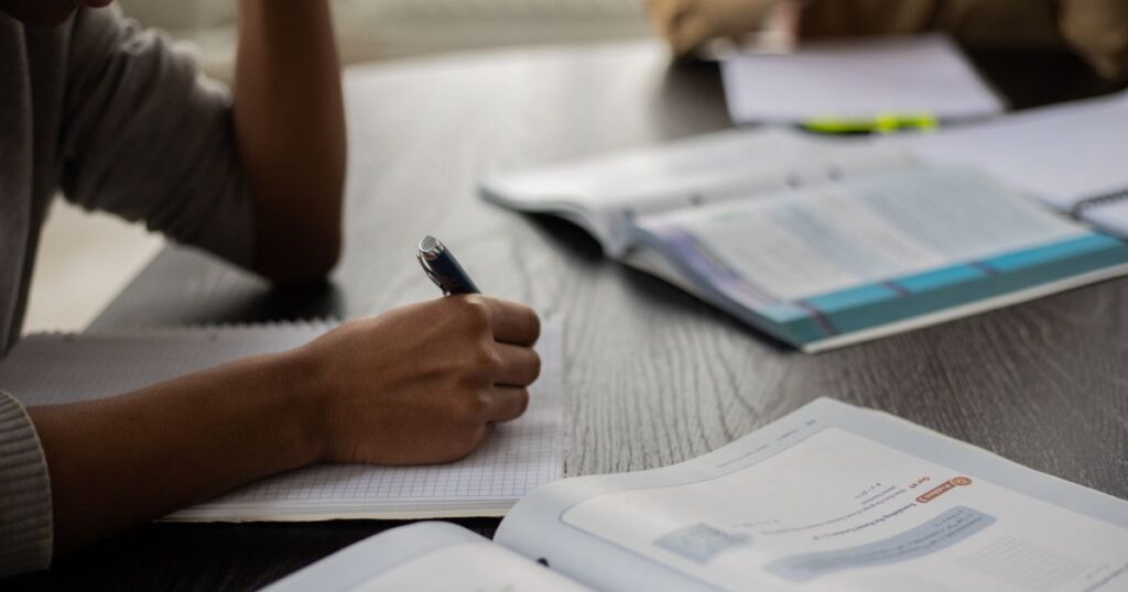 Nigerian student writing an essay conclusion by hand