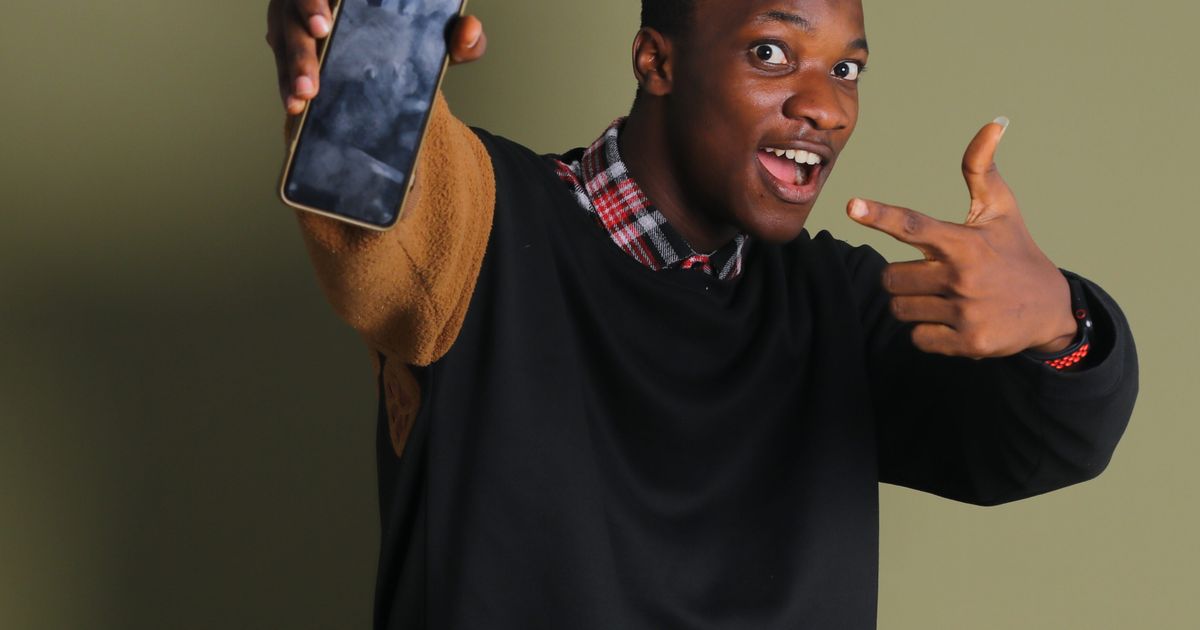 Excited Nigerian student checking JAMB CAPS admission status on a phone