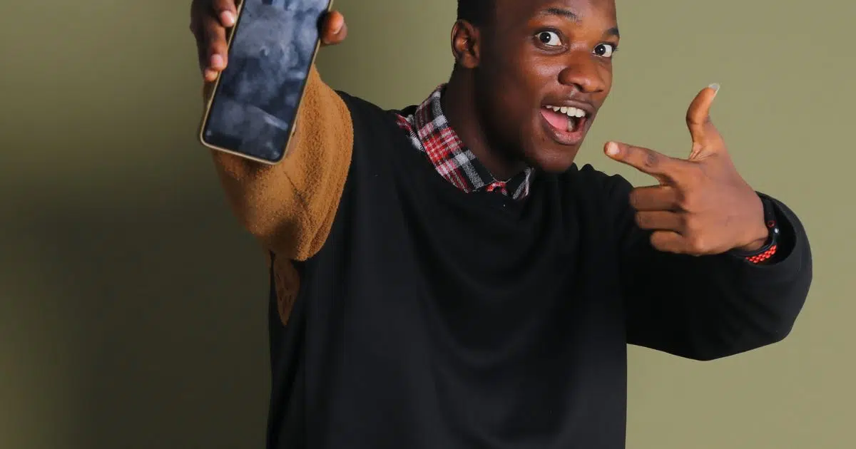 Excited Nigerian student checking JAMB CAPS admission status on a phone