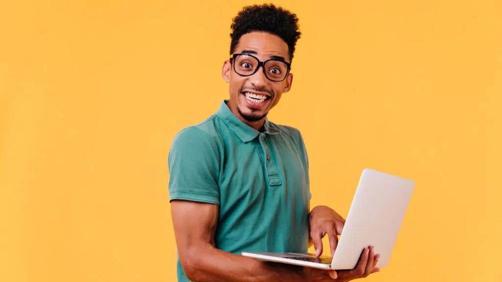 Smiling Black African student holding a laptop after checking an acceptance fee payment