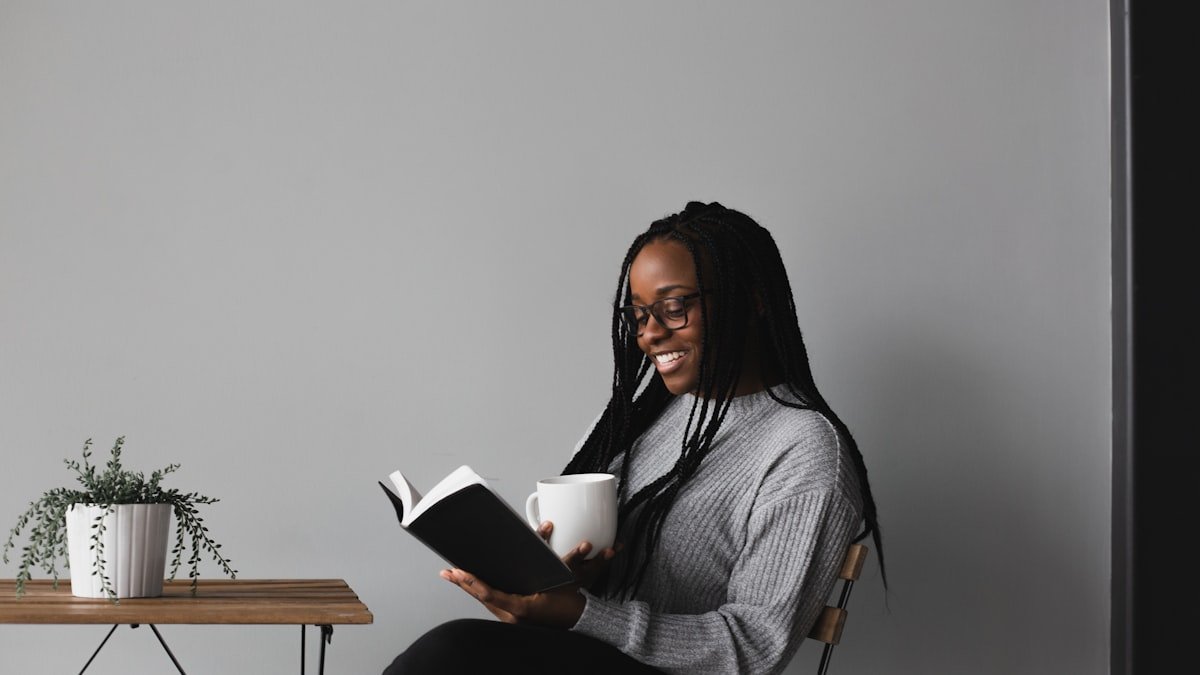 Nigerian student reading a printed book while researching her final year project