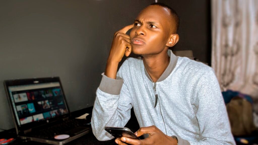 WAEC withheld result 2026 - young Nigerian student checking his result and thinking about next steps