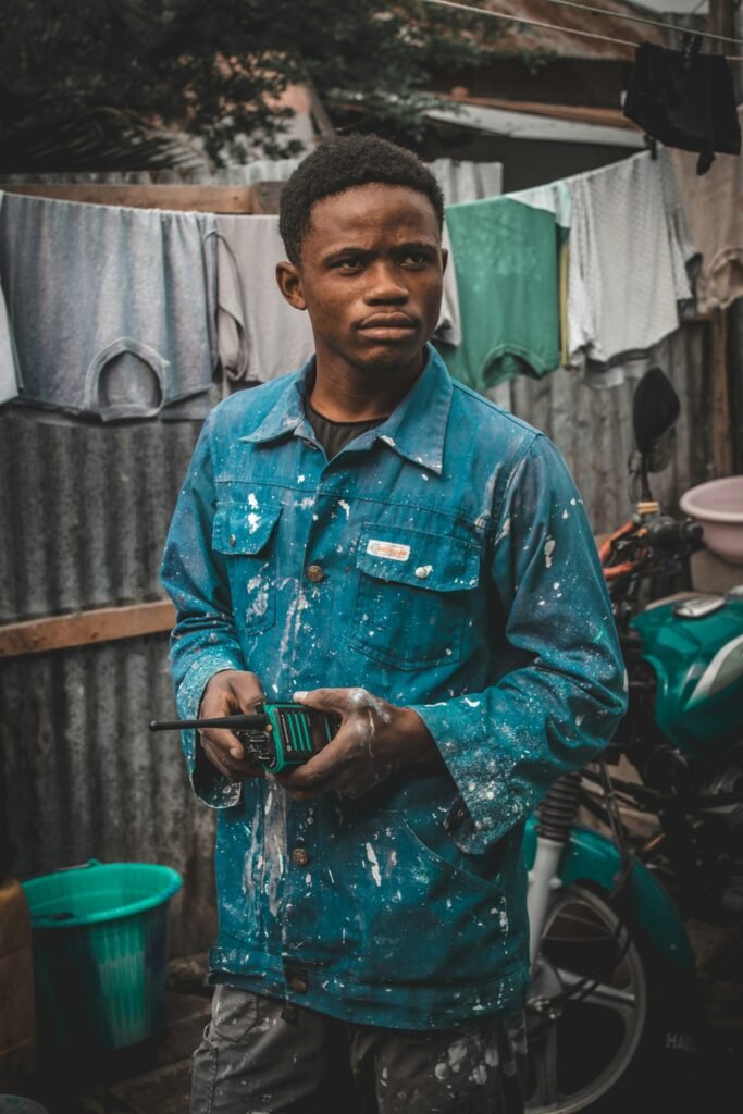 Young Nigerian man in work clothes at a workshop yard during his SIWES industrial training