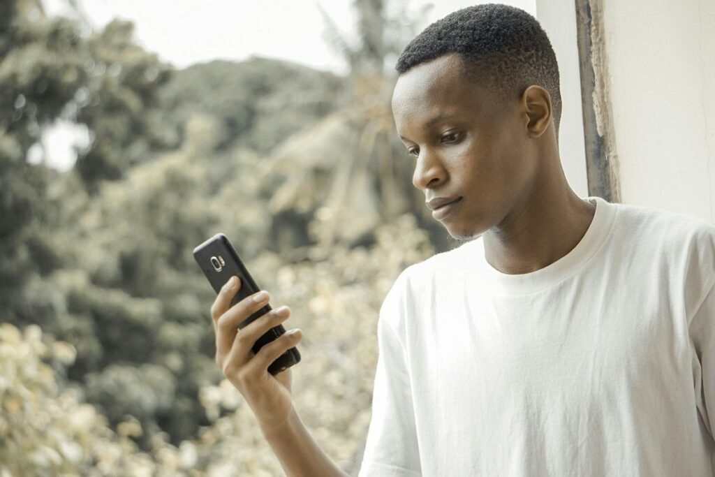 Young Nigerian student checking a JAMB English practice question on his phone