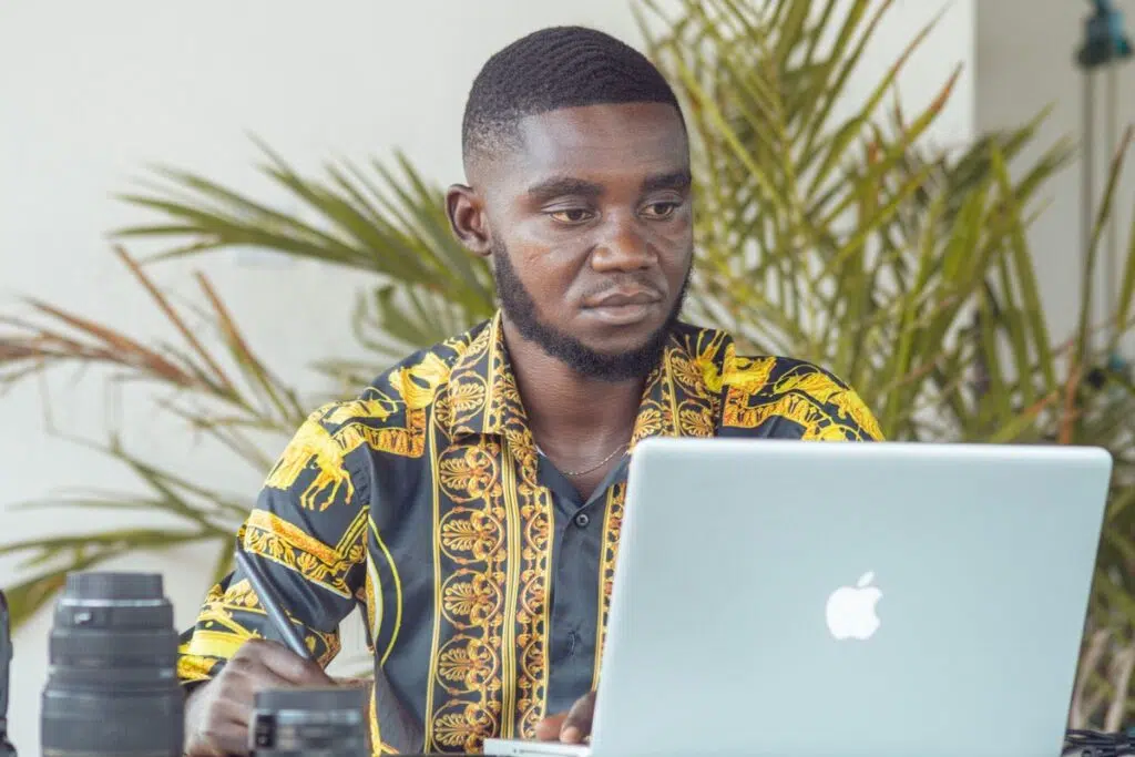 Young Nigerian graduate checking his records at a laptop before applying for the JAMB NIN alignment service