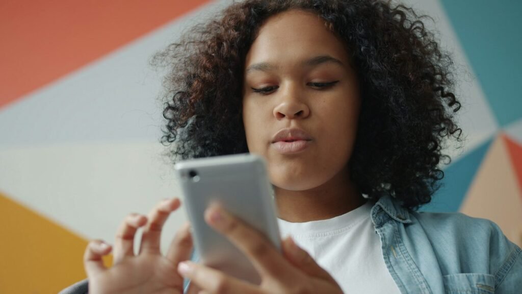 Young Nigerian student checking her phone for a JAMB CAPS admission offer