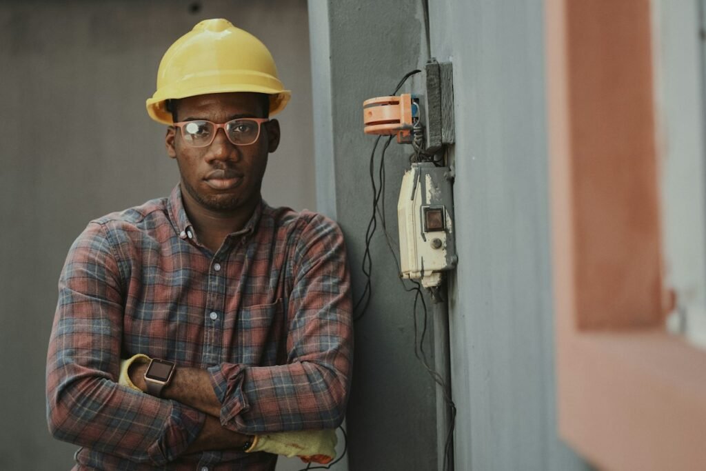 Young Nigerian man in a hard hat on a building site