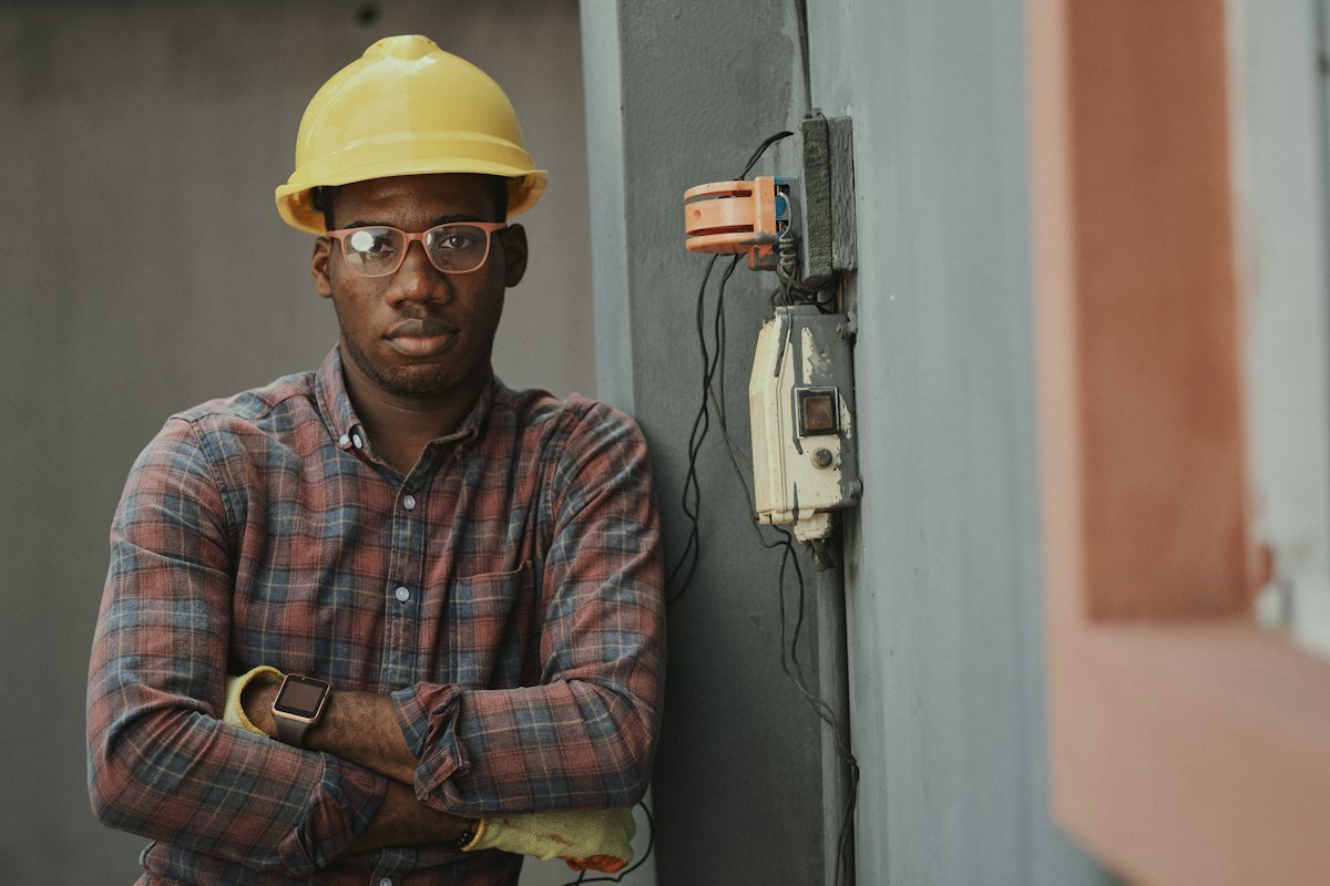 Young Nigerian man in a hard hat on a building site